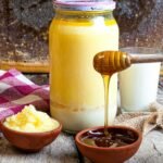 A warm, rustic setup of honey, butter, and milk on a wooden table capturing natural sweetness.