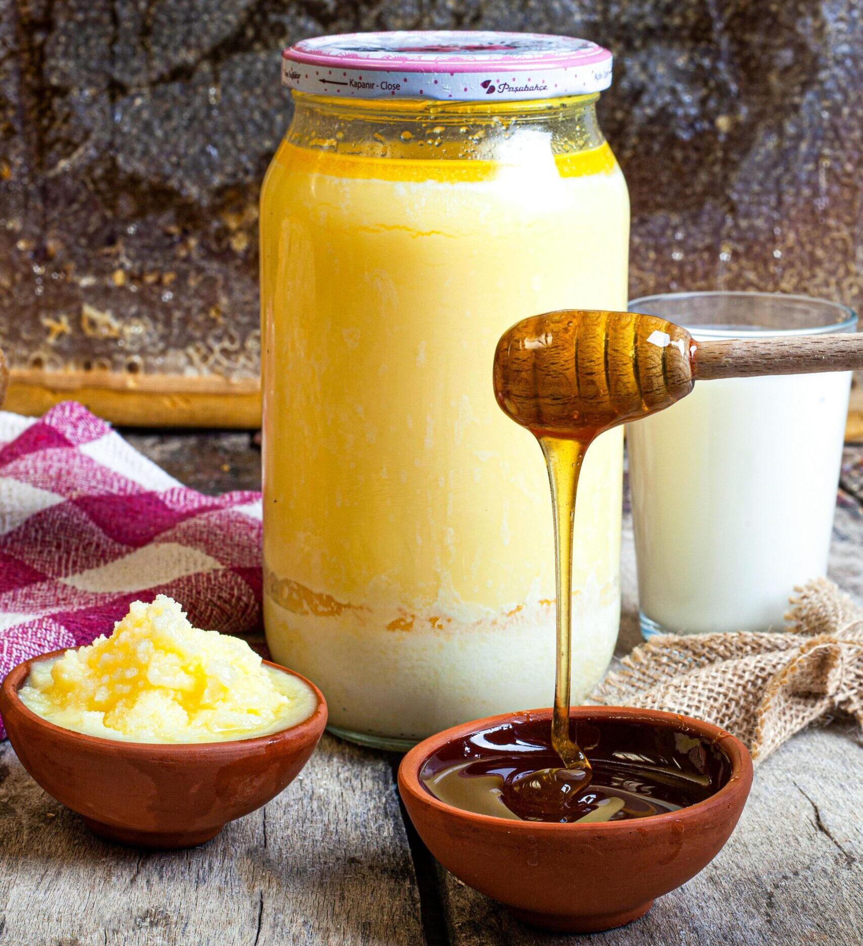 A warm, rustic setup of honey, butter, and milk on a wooden table capturing natural sweetness.